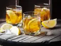 Trzy szklanki z bursztynowym napojem i plasterkami cytryny. Czy to metaxa, co to za drink?