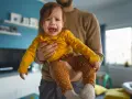 Ein weinendes Kind (2 Jahre) wird von seinem Vater gehalten. Es sagt "Mama weg!" und ist untröstlich.