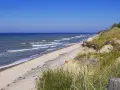 Plaża nad Bałtykiem, fale rozbijają się o brzeg. Czy morze bałtyckie jest słone? Tak, nawet w upalny dzień.