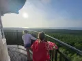 Dwie dziewczynki podziwiają widok z tarasu stilo latarni na morze i las.