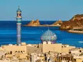 Błękitny minaret i kopuła meczetu nad Zatoką Omańską. Zastanawiasz się, ile się leci do Omanu?