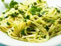 Pyszne spaghetti z zielonym pesto i świeżą natką pietruszki. Idealne na szybki obiad, inspiracja z przepisów z pesto.