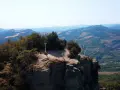 Due escursionisti celebrano la vetta raggiunta sul crinale, un momento clou del cammino della Via degli Dei in 5 giorni.