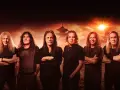 Les membres de Iron Maiden posent devant un paysage asiatique au coucher du soleil.