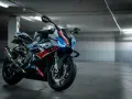 Sportowy motocykl BMW XR w barwach M, z niebieskimi światłami LED, gotowy do jazdy po torze.