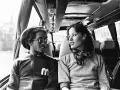 Bob Marley i Kate Marley w autobusie, patrzą na siebie z uśmiechem.