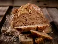 Frisch gebackenes Körnerbrot, angeschnitten auf einem Holzbrett. Perfekt, wann Brot aus der Form nehmen, um diese Kruste zu erhalten.