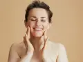 Kobieta z zamkniętymi oczami delikatnie masuje twarz peelingiem. Zastanawiasz się, ile razy w tygodniu robić peeling?
