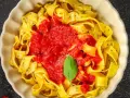 Pappardelle czy fettuccine? Szeroki makaron z sosem pomidorowym i listkiem bazylii, wygląda pysznie!