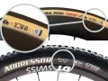 Two bike tires shown. The top is a road tire with a tan sidewall, the bottom is a knobby mountain bike tire. The mountain bike tire shows "60 PSI" as a recommended pressure, answering what psi should mountain bike tires be.