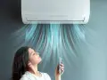 Donna rilassata sotto l'aria fresca di un climatizzatore inverter, che ne spiega il significato di comfort e risparmio energetico.