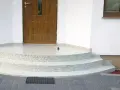 Schody i balkon z żywicy przed drzwiami wejściowymi do domu.