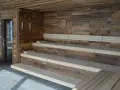 Drewniana, przytulna sauna sucha z wielopoziomowymi ławami. Idealne miejsce na relaks.