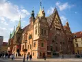 Wrocławski rynek tętni życiem. Wspaniały ratusz z wieloma wieżyczkami i zdobieniami dominuje nad placem.