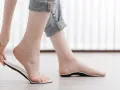 Dłoń trzyma wkładkę ortopedyczną, która idealnie pasuje do stopy w rozmiarze 44. Długość wkładki zapewnia komfort.