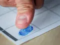 Kciuk z niebieskim odciskiem palca na papierze. Czy to początek śledztwa, czy tylko rutynowa procedura? Jak długo można być podejrzanym?