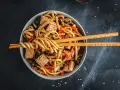 Miseczka z makaronem udon, tofu i warzywami, gotowa do podania. Idealny przepis na pad udon.