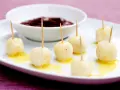 Små, gyllene kroppkakor med tandpetare, serverade med en skål mörk sylt. Ett spännande recept att prova!