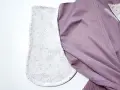 Détail d'un vêtement en cours de confection, montrant la doublure à motifs floraux des poches italiennes et le tissu extérieur violet.