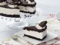 Una deliciosa tarta de oreo, con una base de galleta oscura y un cremoso relleno blanco, decorada con nata y galletas oreo.