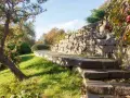 Kamienny murek oporowy tworzy tarasy w ogrodzie. Świetny pomysł na murek oporowy, który dodaje uroku i funkcjonalności.