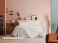 Camera da letto moderna con letto king-size, biancheria grigia e coperta color crema. Idee per come abbellire una camera da letto con decorazioni astratte e piante.