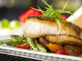 Aromatyczny halibut na talerzu z pieczonymi ziemniakami, szparagami i pomidorkami. Zapach halibut na jakie ryby?