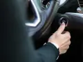 Dłoń naciska przycisk "ENGINE START/STOP". Niestety, samochód nie odpala, co frustruje kierowcę.