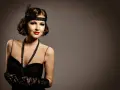 Elegancka kobieta w stylu makijaż lat 20., z opaską na głowie i czerwoną szminką, w czarnej sukni i koronkowej rękawiczce.
