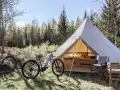 Två elcyklar står redo för äventyr vid ett stort tält på Bengts camping. Skogen bakom bjuder in till utforskning.