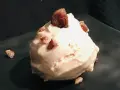 Cremiges Maronen Eis, garniert mit kleinen Maronenstückchen, auf einem dunklen Teller. Ein Genuss für kalte Tage.