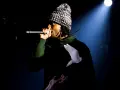 Playboi Carti Polska na scenie, w czapce i bluzie z gołębiem.