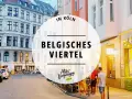 Abendstimmung im Belgischen Viertel in Köln. Menschen sitzen vor beleuchteten Geschäften, Autos parken am Straßenrand.