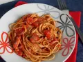 Pyszne spaghetti napoli przepis na talerzu, z sosem pomidorowym i ziołami. Idealne danie dla miłośników włoskiej kuchni.