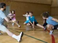 Un entraîneur guide des enfants lors d'une séance d'étirements. L'accueil des mineurs dans cette association sportive est une priorité.