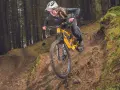 A mountain biker navigates a steep, wooded trail, showcasing the thrill of downhill mtb trails.