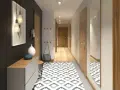 Un corridoio stretto con un tappeto geometrico, mobili moderni e un quadro astratto. Idee per un corridoio che unisce funzionalità ed estetica.