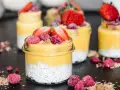 Erfrischender Mango Chia Pudding in Gläsern, garniert mit Erdbeeren und Himbeeren. Ein gesunder Genuss!