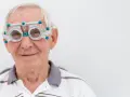 Anziano con occhiali da prova per esame della vista, controlla la vista per prevenire l'invecchiamento precoce della retina.