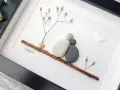 Kamienne serce na 12 rocznicę ślubu. Dwie kamienne postacie siedzą przytulone na gałązce, symbolizując miłość i wspólne lata.