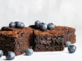 Keto brownie z mascarpone, udekorowane świeżymi borówkami. Idealne na deser bez wyrzutów sumienia.