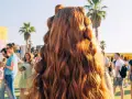 Peinados para festivales: cabello largo y ondulado con secciones recogidas en pequeñas coletas, ideal para disfrutar del sol y la música.