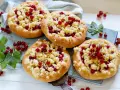 Vier kleine Küchlein mit Streuseln und roten Johannisbeeren, die den köstlichen jostabeere geschmack versprechen.