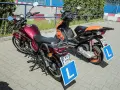 Dwa motorowery z literą "L" na tablicach, symbolizujące naukę jazdy. Od ilu lat można uzyskać kartę motorowerową?