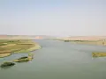 El río Éufrates serpentea entre fértiles campos verdes y áridas colinas.