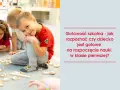 Uśmiechnięty chłopiec w czerwonej koszulce, gotowy do szkoły, bawi się klockami z innymi dziećmi.