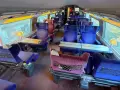 Interior of a bullet train, ready for a journey from Paris to Nice. Plush blue seats with tray tables line the carriage.