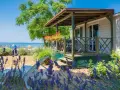 Idealne miejsce, gdzie na wakacje z dziećmi: domek letniskowy blisko plaży, z leżakami i kwitnącą lawendą.
