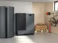 Un puffer per caldaia a pellet, un serbatoio di accumulo e sacchi di pellet in un locale tecnico.