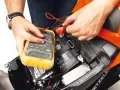 Si accende il quadro ma la moto non parte. Un tecnico controlla la batteria con un multimetro, sperando di risolvere il problema.